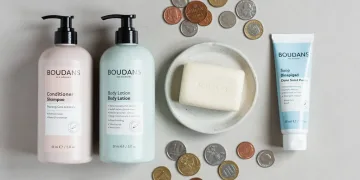 Arrangement of personal care items with coins, symbolizing savings.
