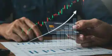 Hand holding credit card with rising credit score graph, symbolizing financial growth